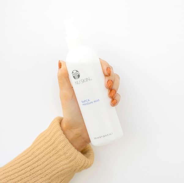 Hand mit NAPCA Spray von Nuskin