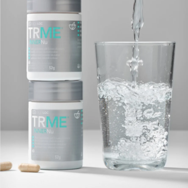 Pharmanex Inner Nu mit einem Glas Wasser