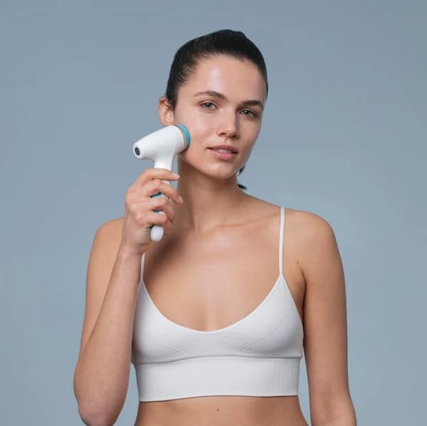Nu Skin mit Modell und blauer Lumispa iO in der Hand Nu Skin mit Modell und blauer Lumispa iO in der Hand